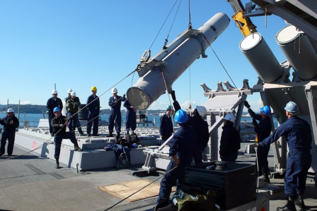 Loading a Mk 141 canister launcher, the deck-mounted launch system used to fire anti-ship missiles such as the Harpoon.