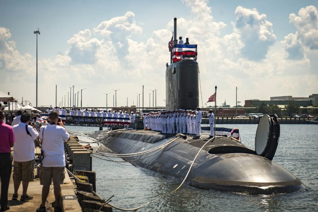 The USS John Warner (SSN-785) entered service with the U.S. Navy during its commissioning ceremony at Naval Station Norfolk, marking the arrival of the 12th Virginia-class submarine in the fleet. As the first of its class to be homeported in Norfolk, the submarine represents the continued expansion of a platform designed for stealth, intelligence gathering, and precision strike in contested environments. Events like these highlight not just the addition of a single vessel, but the steady scaling of one of the most advanced and costly undersea capabilities in modern naval warfare.Credit: U.S. Navy / Photo by Casey Hopkins